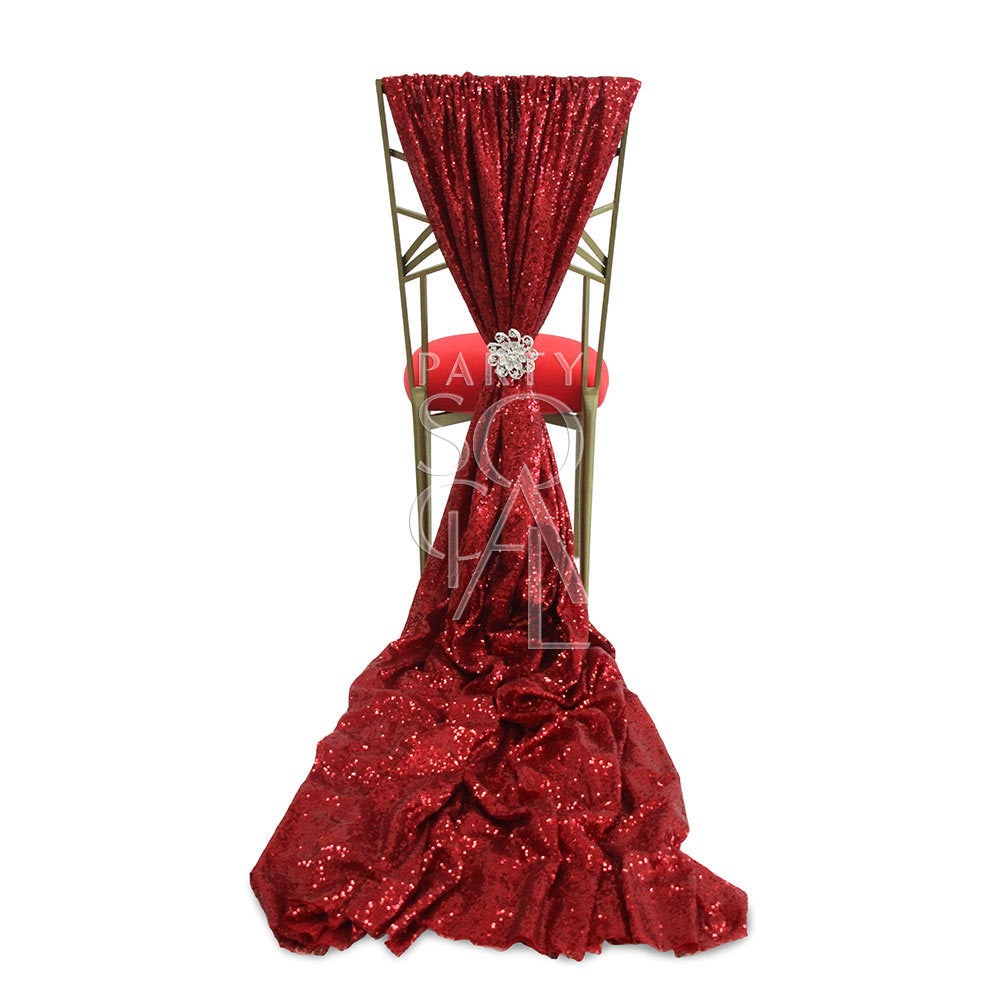 CHAIR COVER RED SEQUIN TRAIN CHAMELEON: A red sequin chair cover with elegant embellishments, designed for a Chameleon chair, adding drama to event settings.