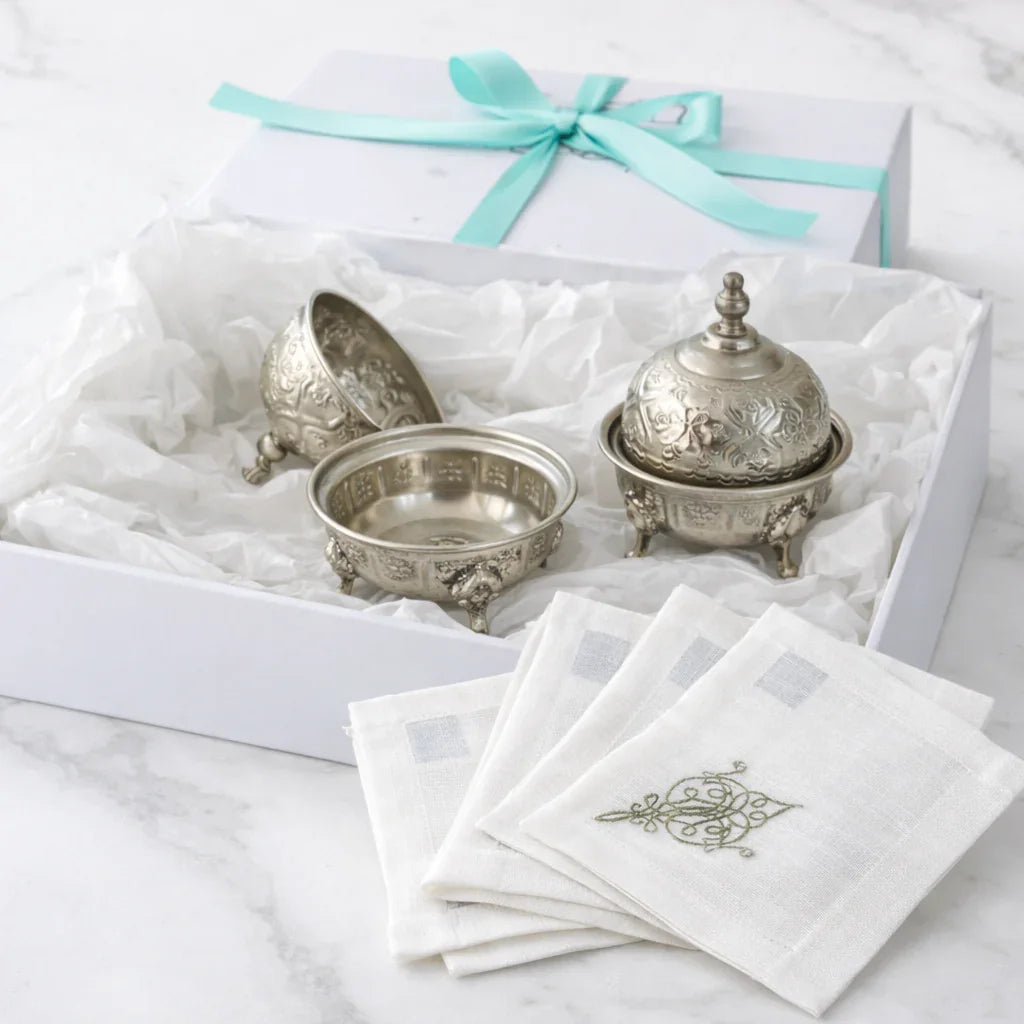 The Silver Ritual Edit Gift Box with silver-plated dishes and embroidered linen napkins, elegantly presented for Ramadan gifting on a marble surface.