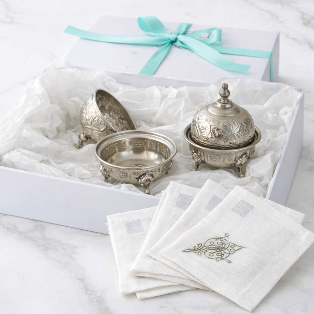 The Silver Ritual Edit Gift Box with silver-plated dishes and embroidered linen napkins, elegantly presented for Ramadan gifting on a marble surface.