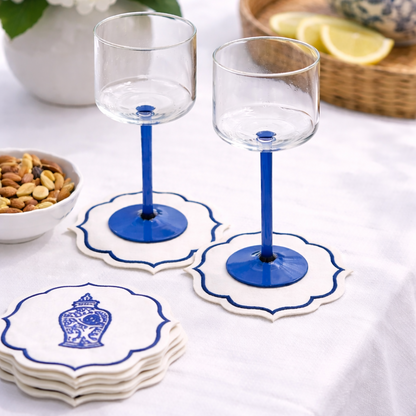 Cobalt-blue stemmed glasses on embroidered linen coasters with a bowl of nuts, part of Party Social&