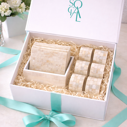 The Crescent Pearl Entertaining Set: a gift box featuring cream-toned mosaic coasters with a holder and six matching napkin rings, perfect for elegant hosting.