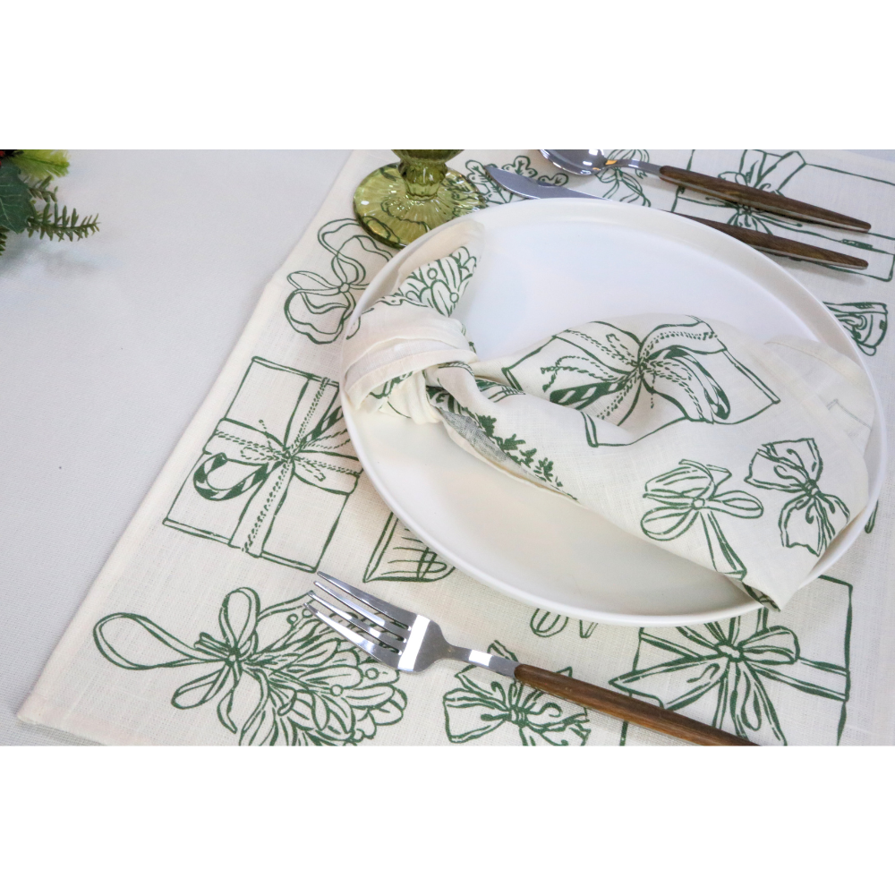 Holiday Icon Linen Napkin, elegantly displayed on a festive table setting with matching runner, wooden-handle cutlery, and a green-tinted goblet, perfect for enhancing holiday meals.