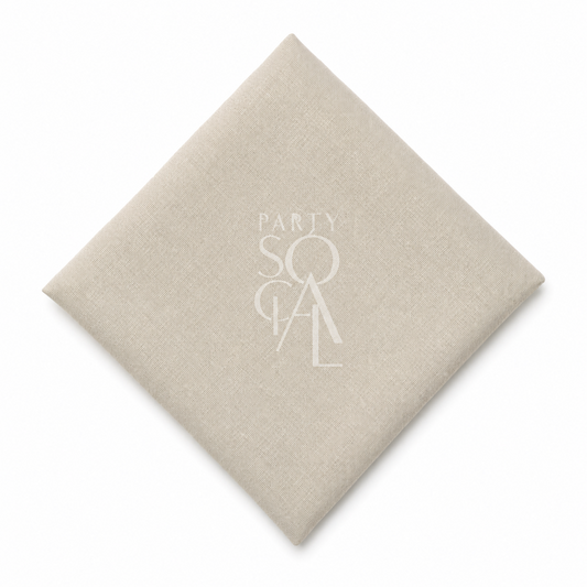 A square beige linen napkin displayed diagonally on a clean white background.