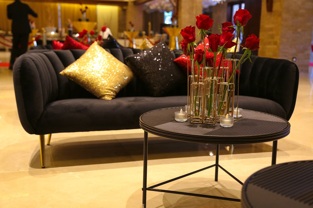 Black lined coffee table surrounded by red roses and candles, suitable for corporate events and home functions from Party Social.