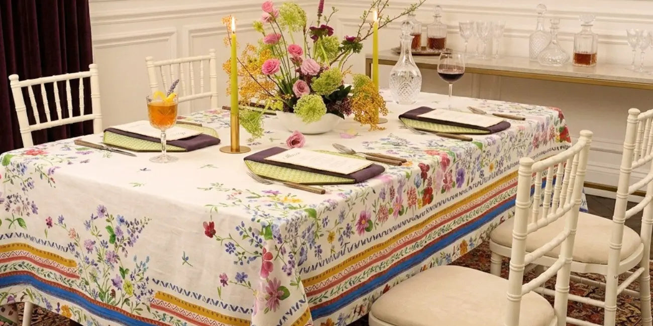 Dining table set with floral tablecloth in a home setting.