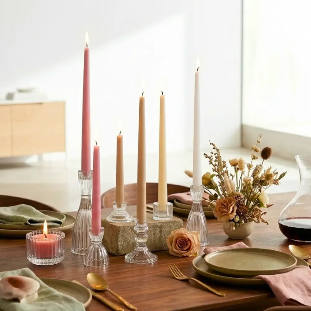 Dining table set with  elegant colored tapered candles, plates, and flowers in a home setting