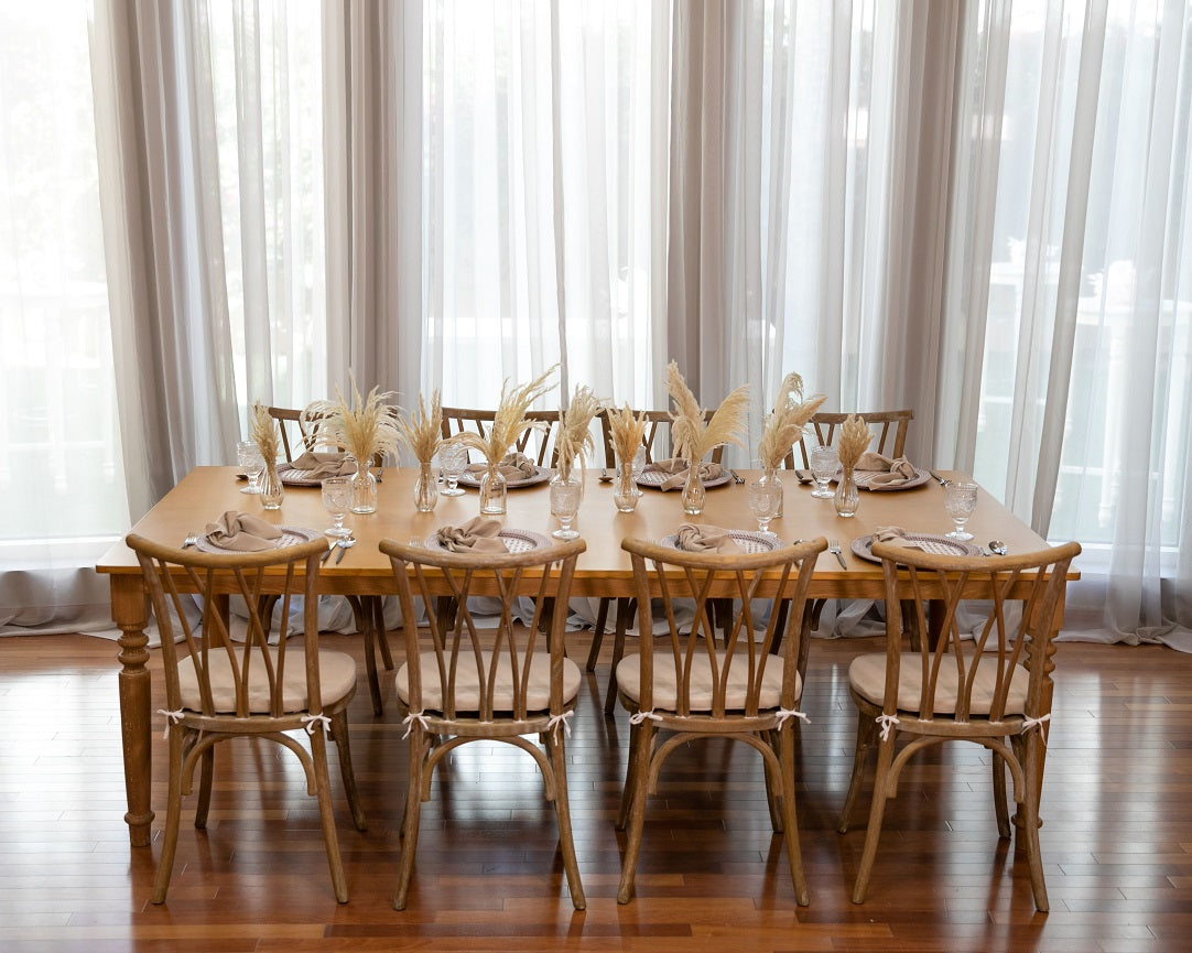 Crisscross Chair Oak Wood elegantly set around a dining table with glasses and vases, ideal for events by Party Social.