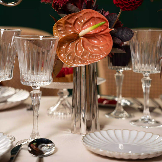 Crystal Paris Glassware Collection showcased with a fluted wine goblet in an elegant formal table setting, featuring a metallic vase with vibrant floral arrangement.