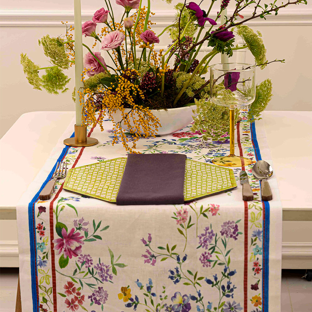 Vibrant Primrose Pure Linen Runner on a decorated table with flowers, vase, and cutlery.