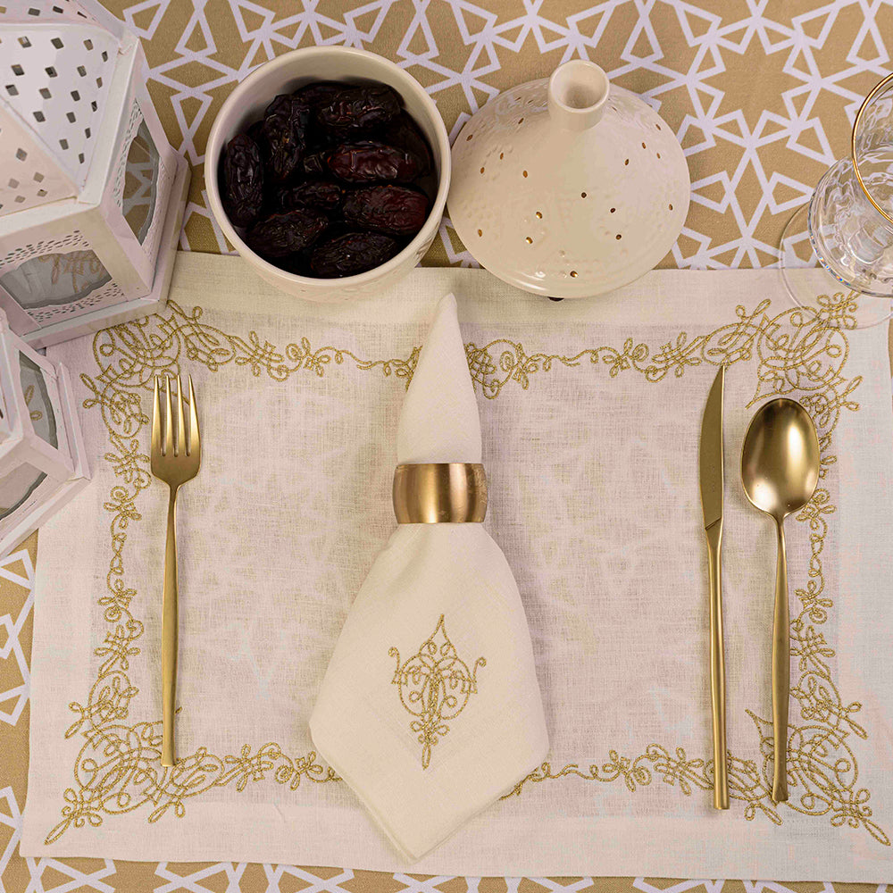 A table setting with a bowl of dates, a napkin, and gold utensils.