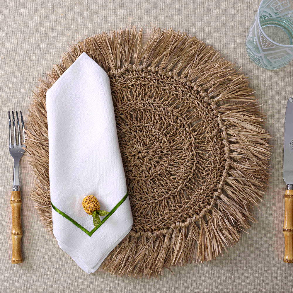Round Woven Seagrass Placemat with napkin, knife, fork, and glass on table setting.