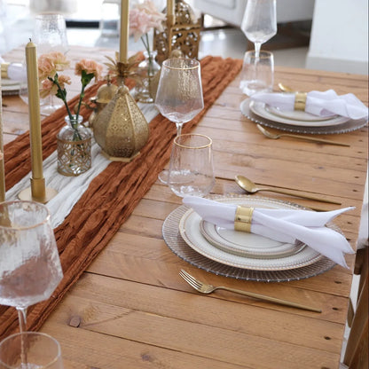 The Noor Royale - Dinner Setup features a wooden table with elegant place settings, gold cutlery, and decorative lanterns, perfect for a sophisticated party gathering.