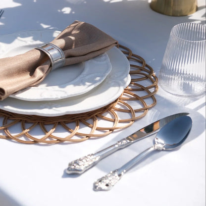 Luxe Alfresco - Dinner Setup featuring elegant place setting with rattan charger, embossed plates, silver cutlery, napkin, and ribbed tumbler for eight guests.