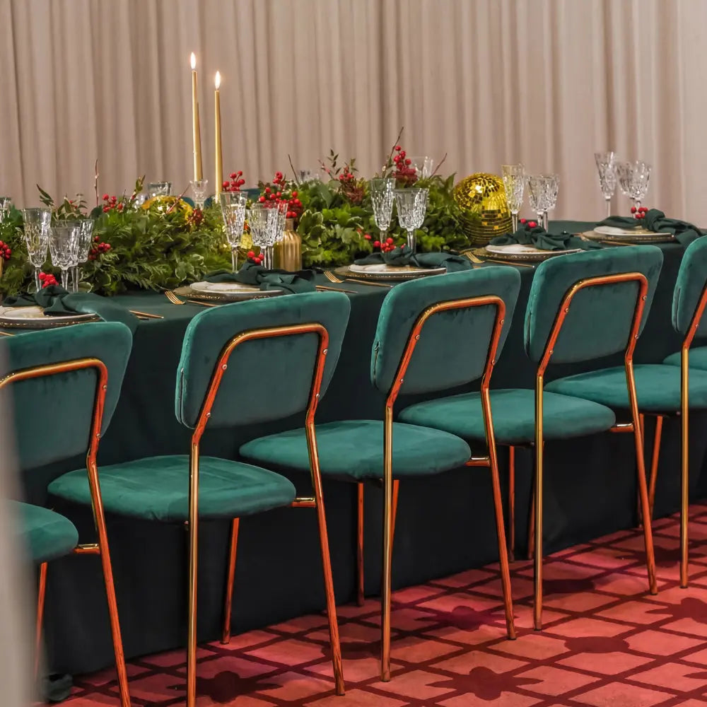 Simple Velvet Chairs with gold legs surround an elegantly set banquet table, featuring plush seating ideal for high-end celebrations and festive gatherings.