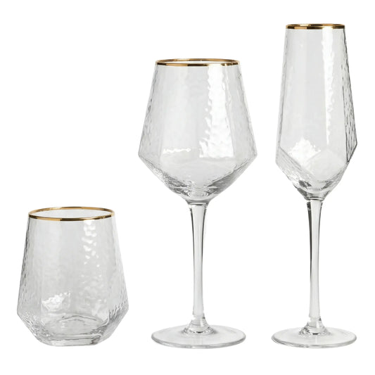 Geometric Gold Rim Glassware Collection: three textured glass pieces—tumbler, wine glass, champagne flute—each with a hammered finish and gold rim, perfect for elegant event settings.