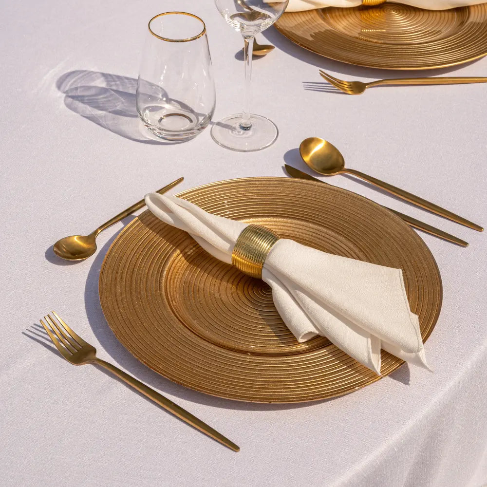 CHARGER PLATE - GOLD LINED elegantly set with gold flatware and glasses, exemplifying refined table decor for special occasions or everyday luxury.