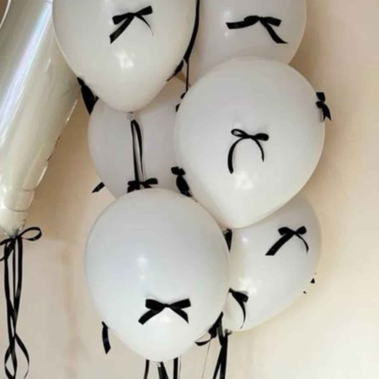 Signature Letter Balloon Bouquet featuring white helium balloons with black ribbon bows, including customizable alphabetical balloons for an elegant, dreamy graduation decoration by Party Social.