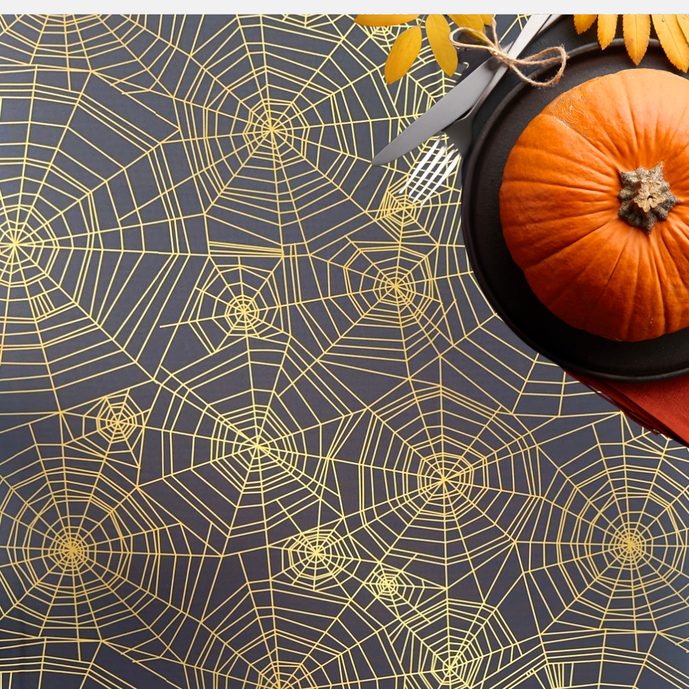 Spider Web Polyester Halloween Tablecloth on a table with a pumpkin centerpiece and cutlery, enhancing festive table settings for parties and events.