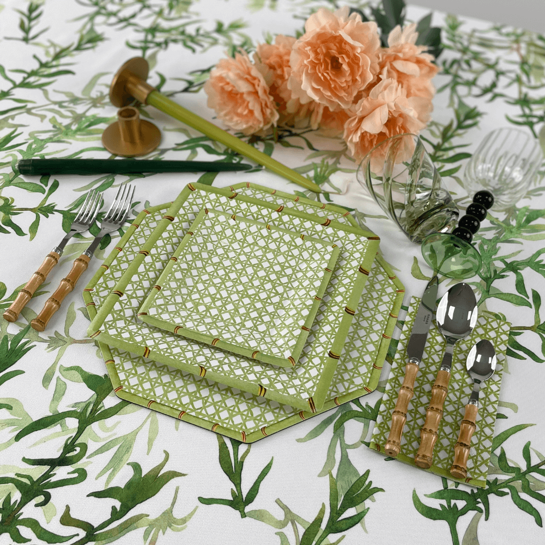 Holly Trellis Square Paper Salad &amp; Dessert Plates on a table with floral tablecloth, spoon, fork, knife, and glasses; ideal for elegant, effortless dining.