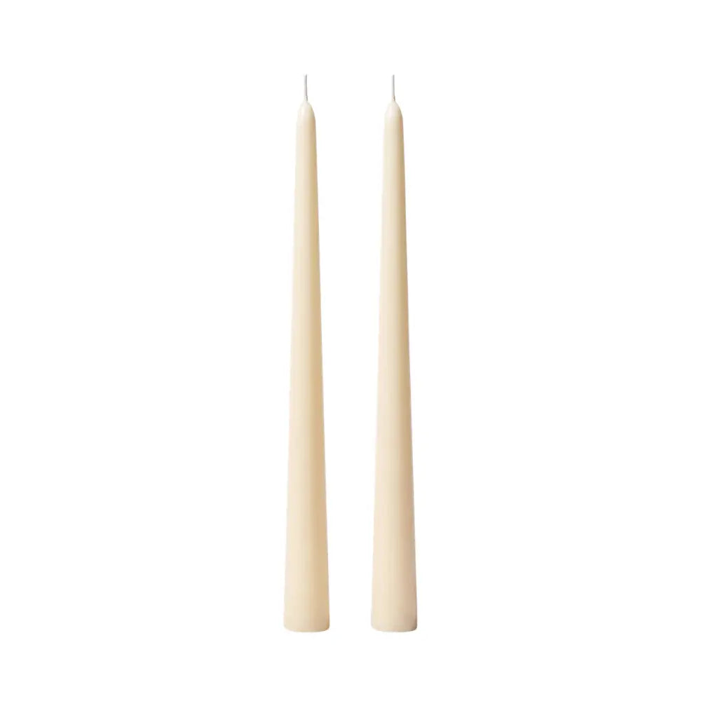 Two slim taper candles in a warm cream or ivory color, standing upright side by side on a plain white background.