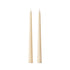 Two slim taper candles in a warm cream or ivory color, standing upright side by side on a plain white background.