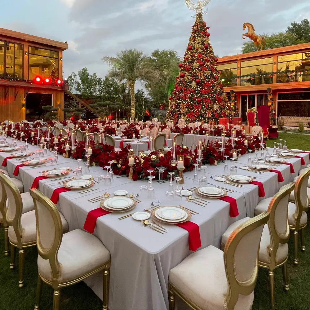 Rectangular Tablecloth Cotton Linen elegantly drapes U-shaped banquet tables set for a holiday event, featuring fine china and gold flatware amidst festive decor.