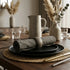 Dining table set with plates, glasses, and cutlery in a home setting.