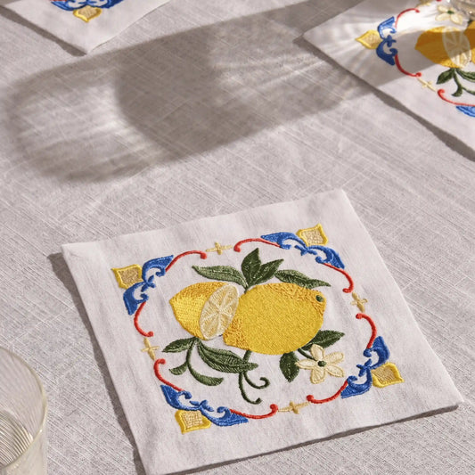 Embroidered napkin with lemon design on a textured surface