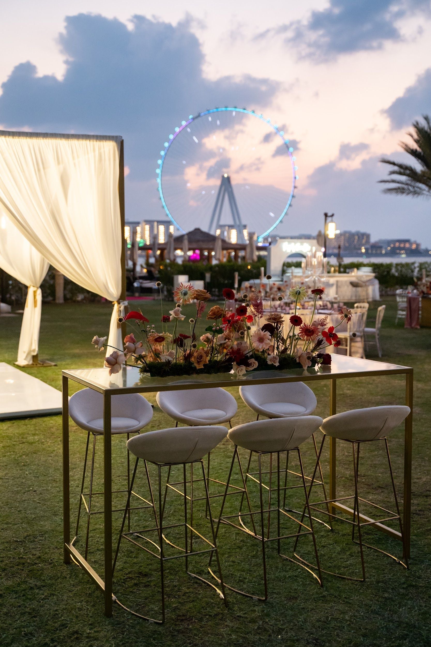 High Glass Rectangular Table with Gold Base, set outdoors near a ferris wheel, ideal for corporate events, complements Party Social&