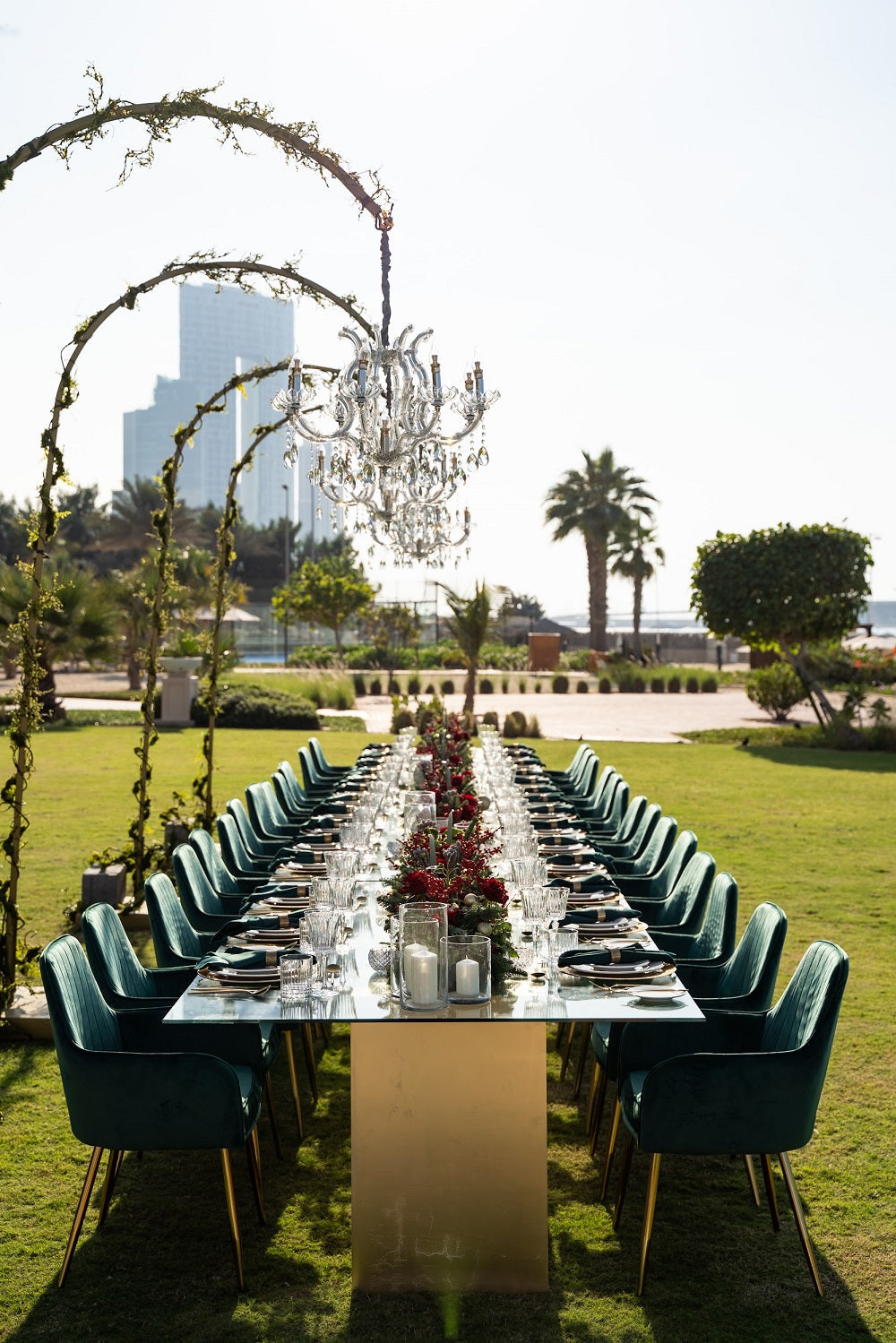 GLASS DINING TABLE set for an elegant dinner, featuring a clear glass top and white wooden bases, perfect for events and home functions.