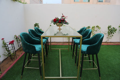 High Glass Rectangular Table with Gold Base surrounded by chairs, featuring a vase with flowers, ideal for corporate events and home functions.