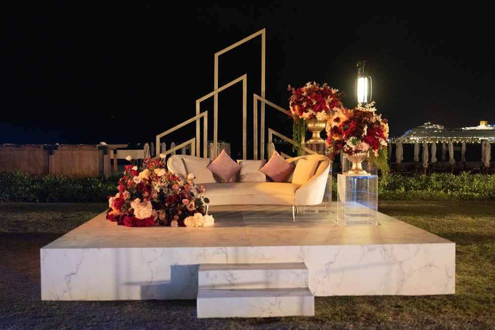 ASYMMETRIC ABSTRACT BACKDROP with a white couch and floral arrangement on a marble platform, ideal for weddings and events.