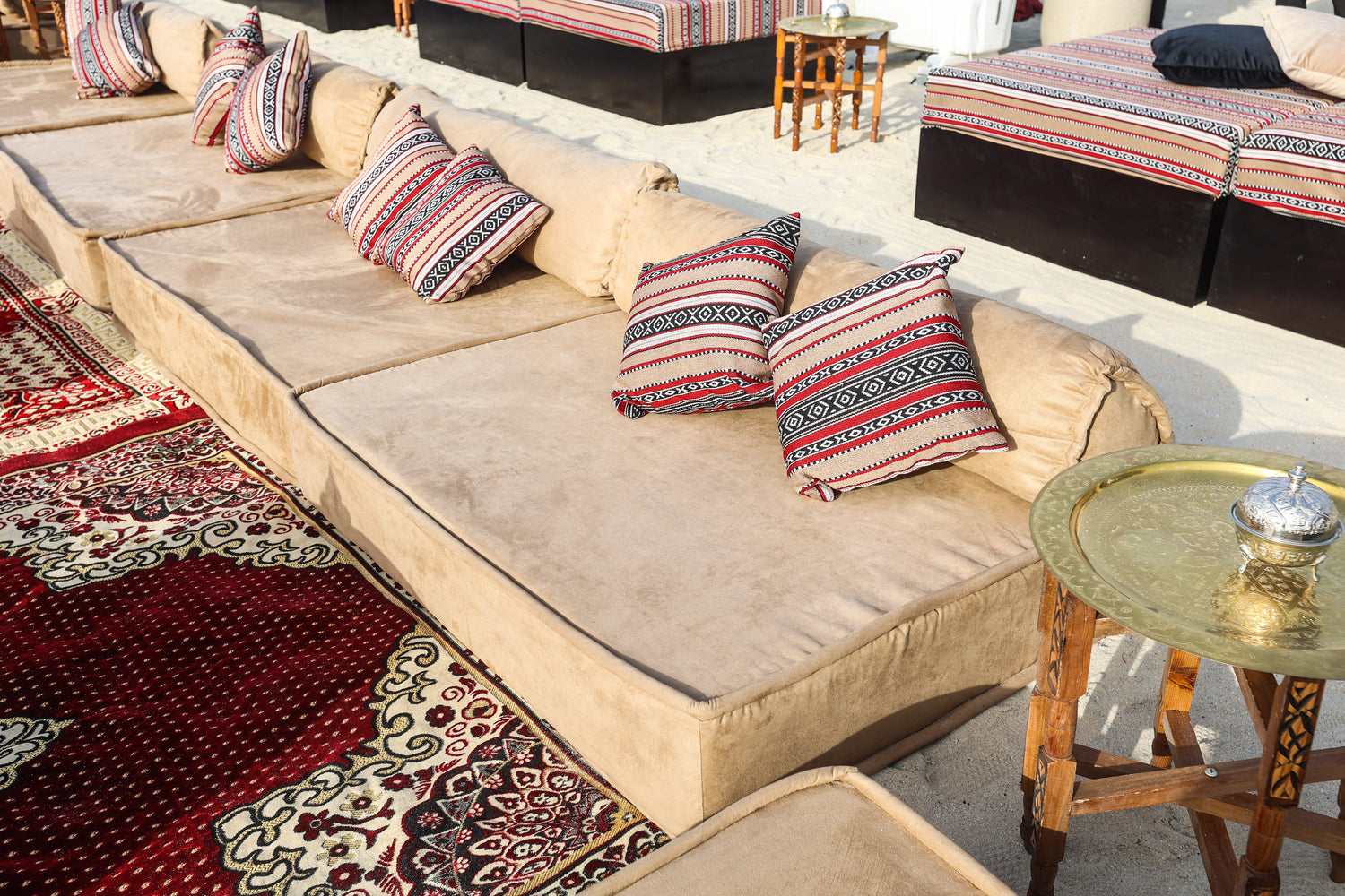 LOUNGE LOW SEATING: Comfortable couch with multiple pillows, ideal for adding an Arabic touch to outdoor events. Perfect for rental at Party Social.