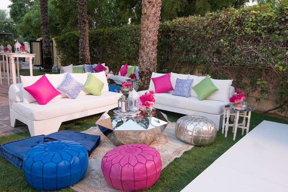 WHITE 3 SEATER LOUNGE in a yard setting, featuring colorful pillows on a blanket, ideal for outdoor events and gatherings.