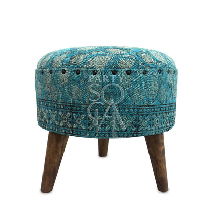 LOW STOOL: A versatile blue ottoman with wooden legs, ideal for seating or as a decorative element in event settings.