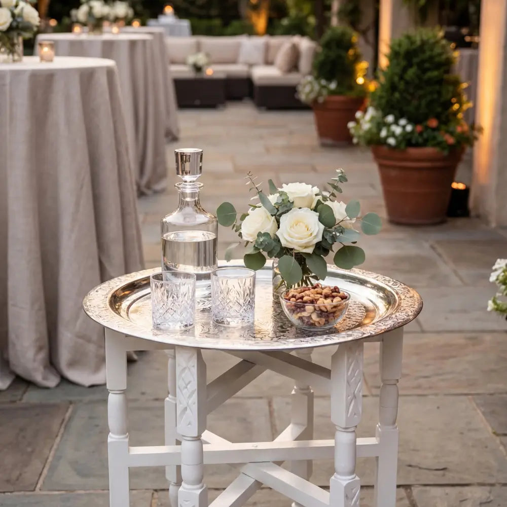 Moroccan Folding Table with a silver tray displaying a decanter, tumblers, nuts, and floral arrangement, ideal for elegant party settings.