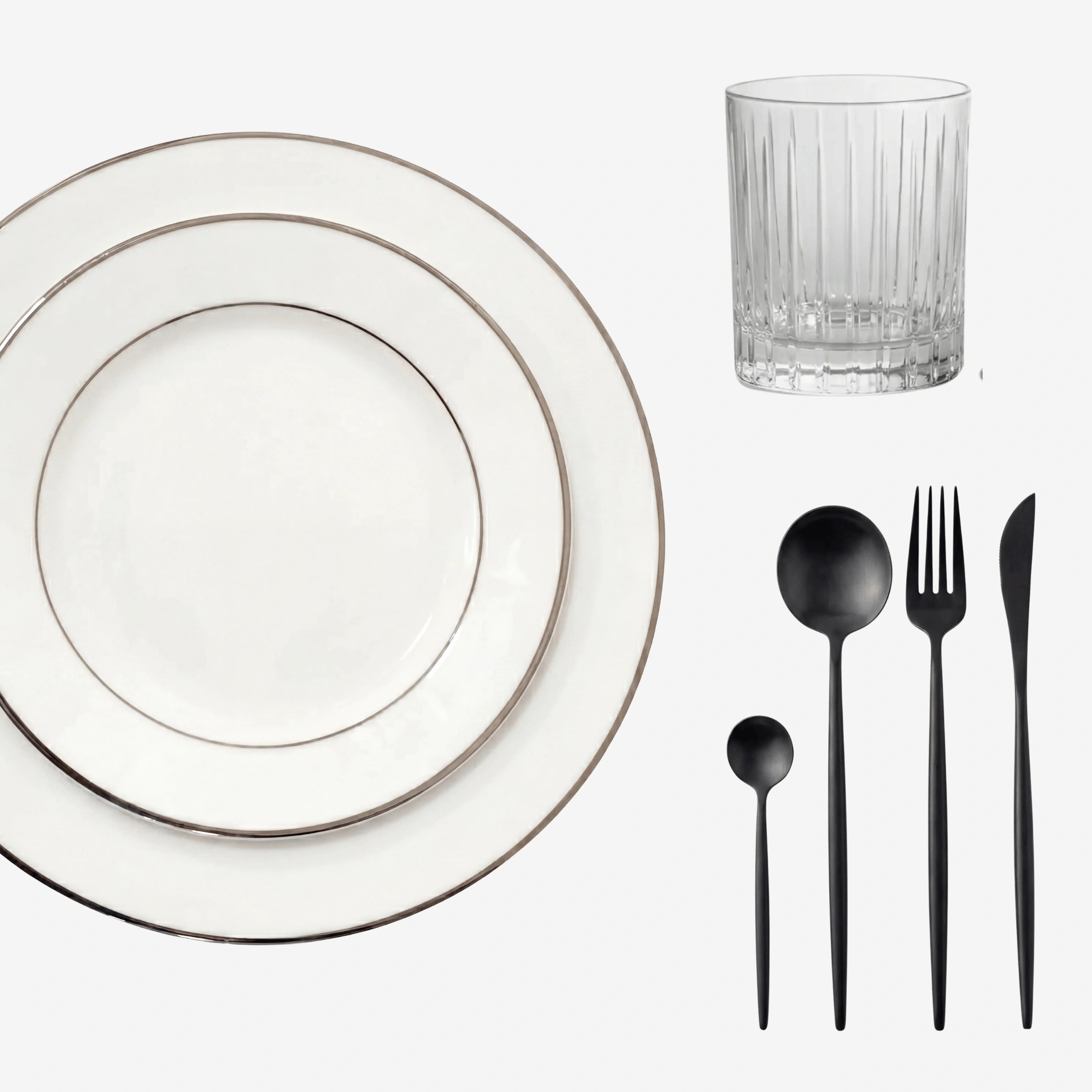Minimalistic Tabletop Package featuring white plates with silver rims, a faceted tumbler, and matte-black flatware, perfect for elegant dining settings.