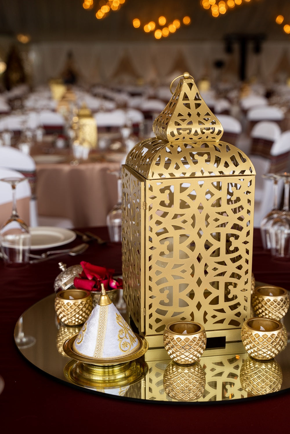 MIRROR CENTERPIECE ROUND on a table, adorned with elegant gold elements, ideal for enhancing party and event decor.