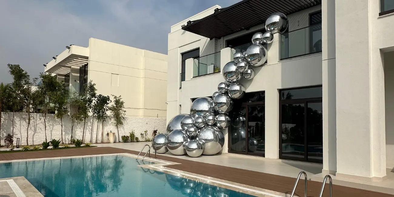 Modern building with a pool and decorative metal spheres.