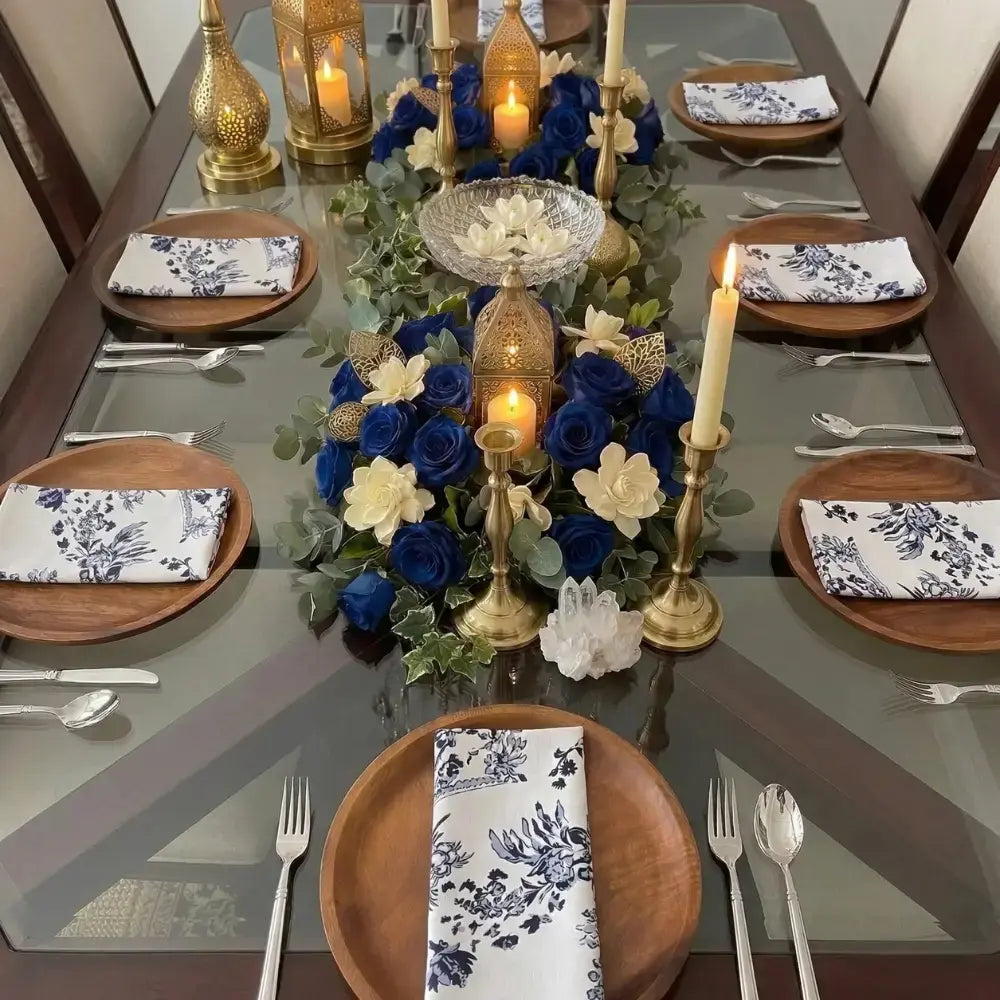 NAPKIN- TOILE DE JOUY adds vintage charm to an elegant dining table set with blue-and-white floral napkins, enhancing the sophisticated candlelit tablescape.