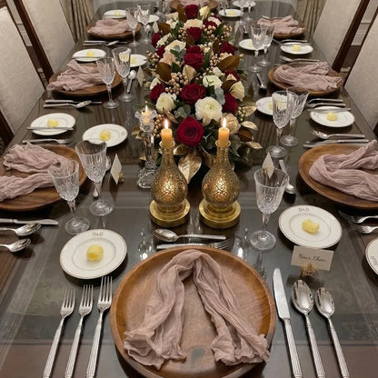 Elegant dining setup featuring NAPKIN GAUZE, loosely folded on wooden chargers, enhancing the formal table with crystal stemware and gold-accented decor for a sophisticated occasion.