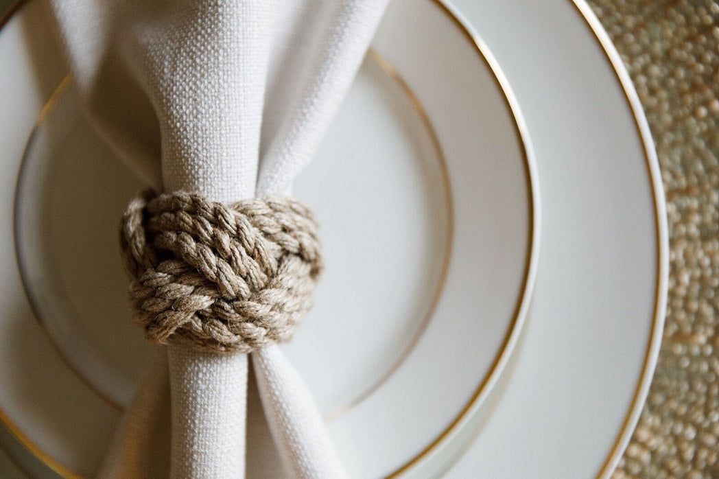 NAPKIN RING - CORDED JUTE ROUND displayed, showcasing its natural texture and intricate knot design, ideal for enhancing any tablescape.