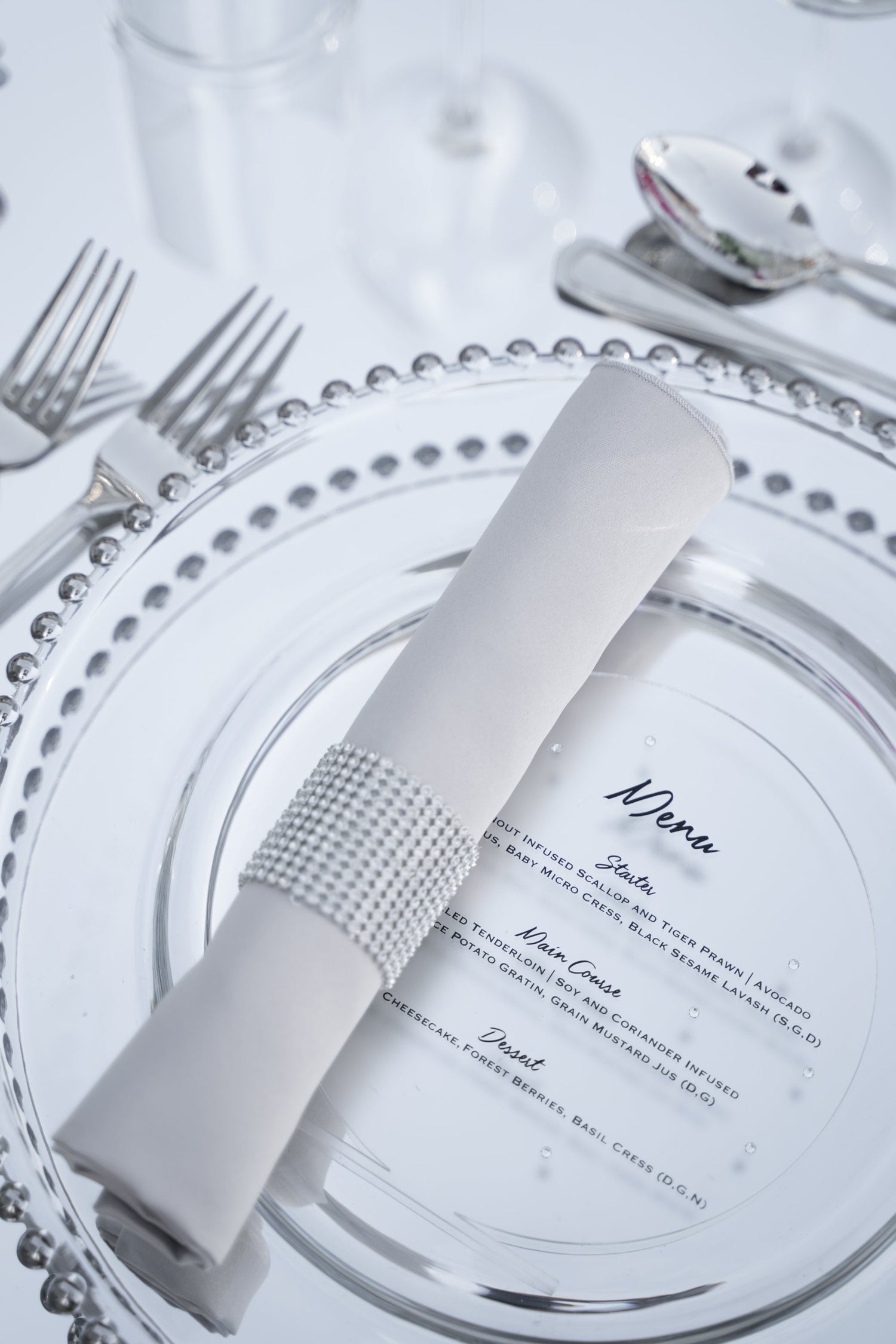 Diamante round napkin ring on a plate with silverware and napkin, enhancing elegant tablescapes for parties and events.