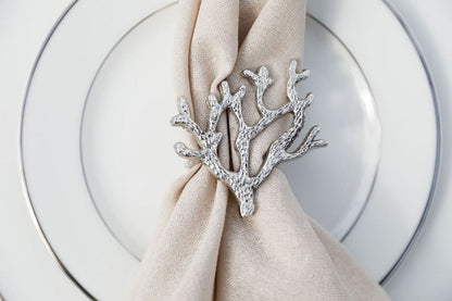 NAPKIN RING - SILVER CORAL: A coral-shaped silver ring elegantly displayed on a napkin, perfect for enhancing any tablescape.