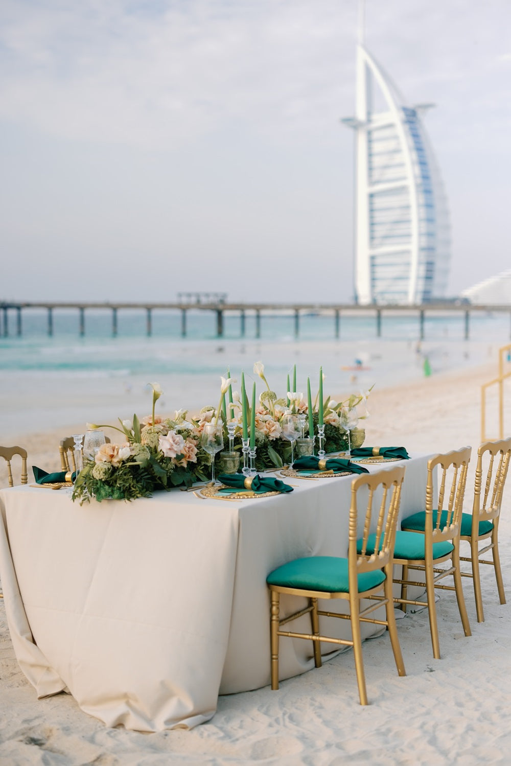 NAPOLEON GOLD CHAIR: An elegant armless chair set on a beach with a decorative table, ideal for weddings and events, highlighting versatility and style.