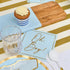 Everyday Sky Blue Luncheon Napkins embossed with Oh Boy! in gold, complementing a stylish baby boy-themed table setting with matching blue and gold tableware.