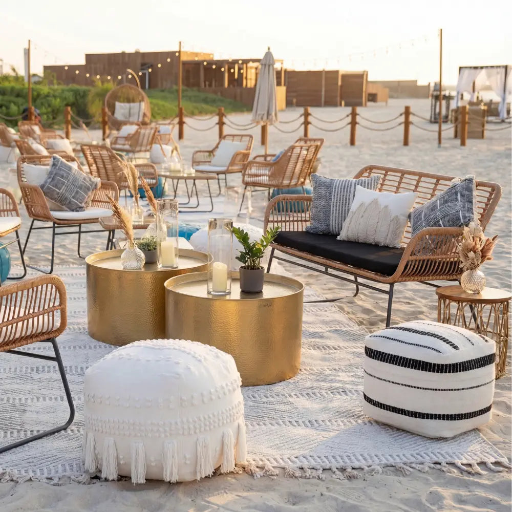 FABRIC &amp; JUTE POUFS in a boho-chic beach lounge setup, featuring a white pouf with tassels and a striped pouf, perfect for cozy gatherings.