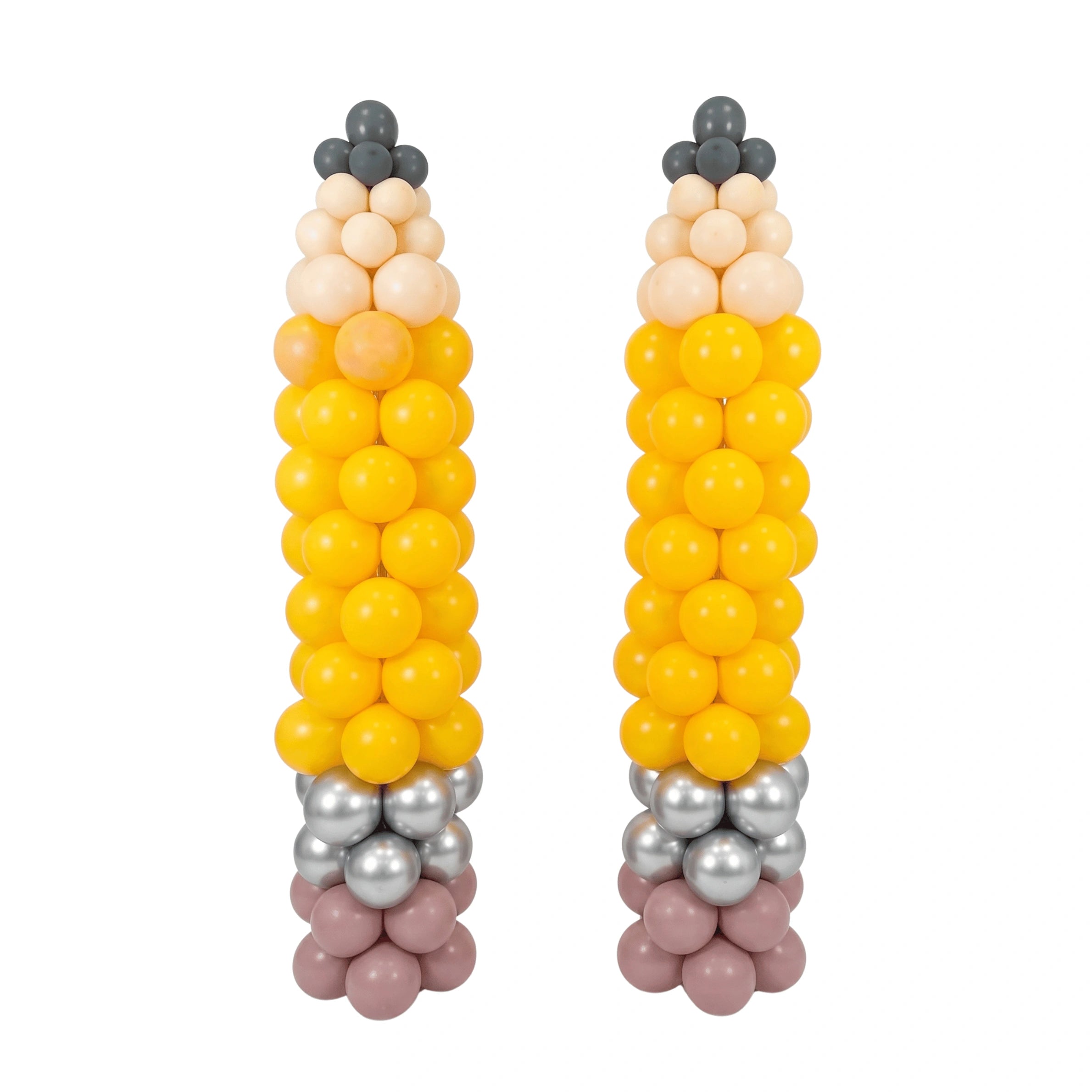 Two balloon sculptures shaped like corn cobs, made from yellow, peach, beige, gray, and dusty pink balloons, set against a plain white background.