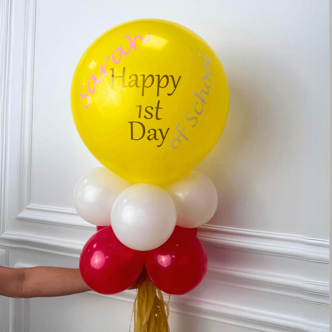 Personalised Back to School Balloon Wand: A vibrant 12-inch yellow balloon with custom writing, surrounded by smaller balloons, perfect for memorable first day of school photos.