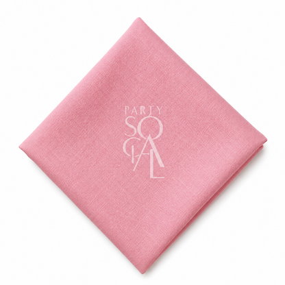 A square pink linen napkin displayed diagonally on a clean white background.

